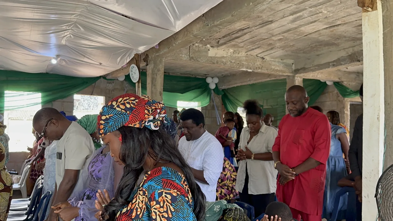 Members of Vision House standing with heads bowed in prayer