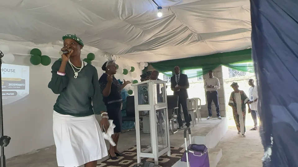 A singer in green leading worship at Vision House