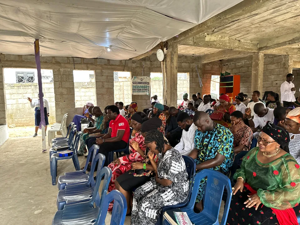 The congregation seated together with heads bowed in prayer